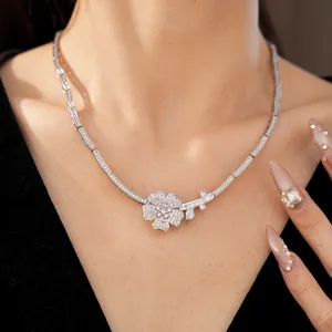 Detailed view of an elegant silver flower necklace featuring pink and white zircons on a model