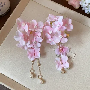 Vista dettagliata dei fermagli per capelli a fiore rosa con eleganti nappe di perle