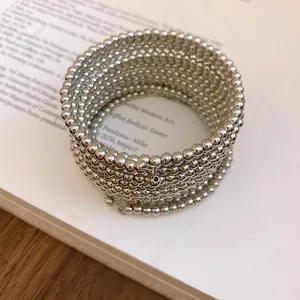 Detailed view of silver multi-layer coiled bracelet with metallic bead texture