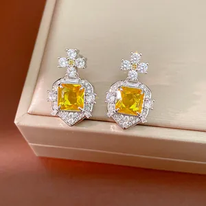 Detailed macro view of vintage square yellow zircon earrings featuring silver star designs