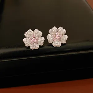 Close-up of sparkling flower stud earrings with pink and white zircon stones