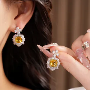 High-definition detail shot of elegant square yellow zircon earrings with vintage cross design
