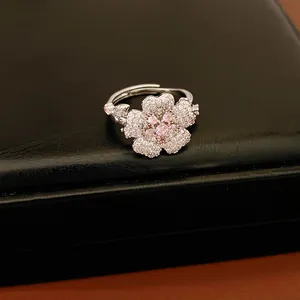 Detail view of an elegant silver zircon flower ring showcased on a black leather background