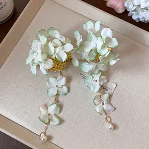 Dettaglio del fermaglio per capelli a fiore con petali a nappa e accenti di perle