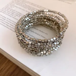 Detailed view of silver multi-layer wrap bracelet with square bead texture