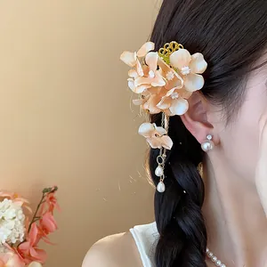 Dettaglio ravvicinato di elegante fermaglio per capelli a fiori con nappe di perle su modella