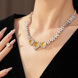Detail shot of a luxury necklace with vibrant yellow square zircons worn by a model
