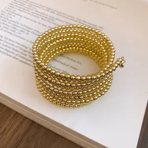 Close-up detail of a minimalist gold multi-layer beaded wrap bracelet with vintage style