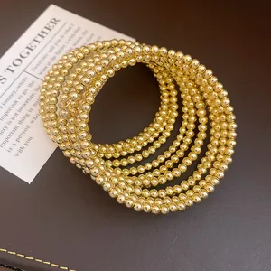Detailed view showing the intricate texture of an elegant multi-layer gold bead coiled bracelet.
