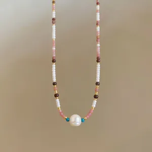 Detailed view of a handmade beaded choker featuring a central white pearl ornament