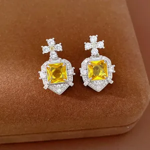 Detailed macro shot of elegant square yellow zircon earrings with sparkling crystal accents
