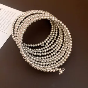 Stylish silver-toned multi-layer beaded wrap bracelet displayed on a dark background