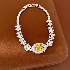 Detailed close-up view of a luxury bracelet featuring a yellow square zircon and floral accents.
