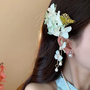 Dettaglio squisito di un fermaglio per capelli a fiore con nappe di perle su modella.