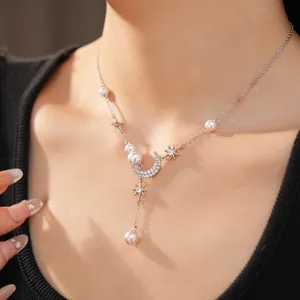 Detailed view of silver star and moon tassel necklace with zircon and pearls on model