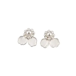 Elegantes pendientes de flores de plata con perlas y pétalos blancos en fondo blanco