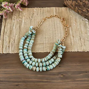 Detailed view of bohemian triple-layered shell bead necklace with adjustable gold chain