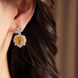 Close-up detail of luxury palace style earring with square yellow zircon and floral stud.