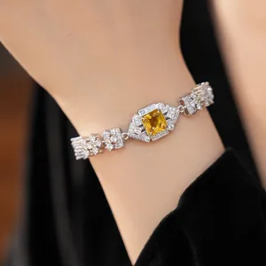 Detailed close-up showing an elegant silver-toned bracelet with a central square yellow zircon