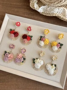 Detalle de pendientes colgantes de flores de tela en vibrantes colores veraniegos
