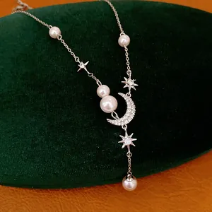 Detail of elegant star and moon pendant necklace with lustrous pearls and zircon