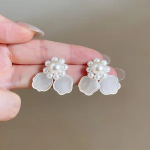 Vista detallada de elegantes pendientes de flor de perlas con pétalos traslúcidos