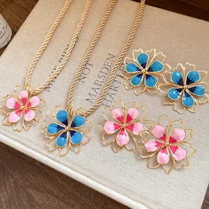 Detailed macro view of vintage gold-tone enamel flower necklace and matching earrings set