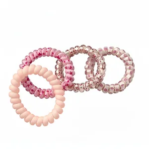 Set mit vier modischen rosa Spiral-Haargummis mit Stern- und Punktmustern in verschiedenen Tönen.