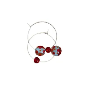 Stylish resin hoop earrings with red polka dot beads and vibrant dopamine aesthetic.