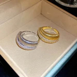 Gros plan de bagues ouvertes texturées dorées et argentées avec détails en pavé de zircone.