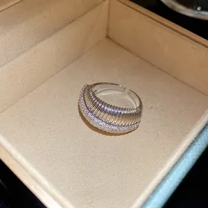 Détail macro d'une bague ajustable argentée texturée sertie de zircons brillants