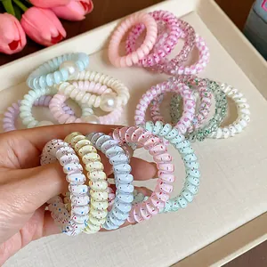 Bunte Spiral-Haargummis mit Streuseln und Perlen in sanften Macaron-Tönen