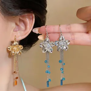 Close-up of French retro glossy flower earrings with elegant glass bead tassels.