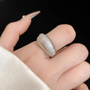 Vue détaillée d'une bague plaquée or 14 carats texturée avec zircons sur un doigt.