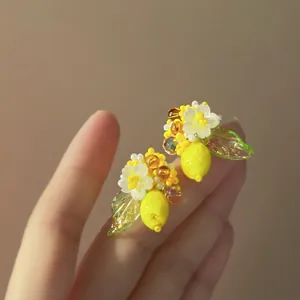 Detailed close-up view of handmade lemon and white flower beaded earrings for summer