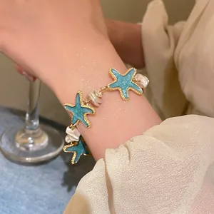 Detailed shot of a mint green starfish and pearl bracelet for beach holiday style.