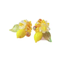 Handmade yellow beaded lemon earrings with white flowers for summer vacation outfits.