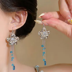 Detailed close-up view of elegant silver flower tassel earrings with blue glass beads