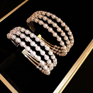 Elegant multi-layer pearl and rhinestone open cuff bracelet in gold and silver finish