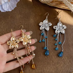 Detailed close-up showing French vintage flower earrings with long glass bead tassels.