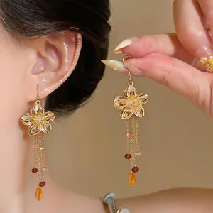 Close-up of French retro gold flower earrings featuring elegant long glass tassel drops