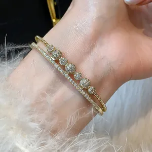 Detalle macro de brazaletes bañados en oro 14K con brillantes esferas de circonitas
