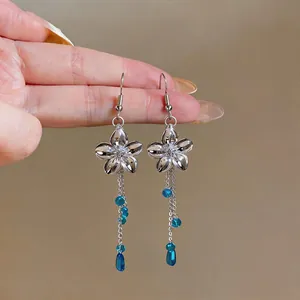 Elegant silver flower dangle earrings with delicate blue glass bead tassels for women.