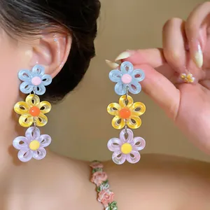 Close-up of colorful acrylic daisy earrings for a sweet summer dopamine look.