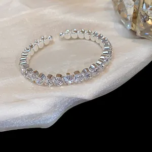 Primer plano de un elegante brazalete abierto geométrico chapado en oro de 14K