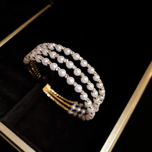 Close-up of triple-layer pearl bracelet with sparkling rhinestone accents in a luxury box