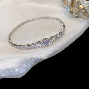 Detalle de brazalete geométrico bañado en oro de 14K con piedras de circonita.