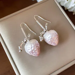 Exquisite close-up of pearlescent pink strawberry hook earrings with sparkling zircon accents