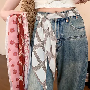 Vintage printed chiffon scarf tied as a belt on denim jeans for a stylish look.