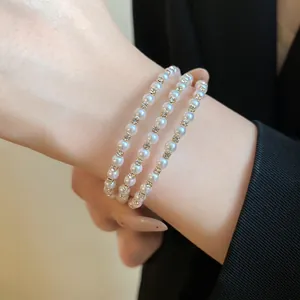 Close-up of three-layer pearl bracelet with sparkling rhinestone accents